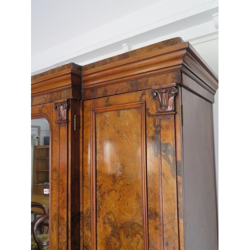 654 - A good quality mid Victorian burr walnut breakfront wardrobe with a central mirrored door flanked by... 