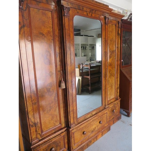 654 - A good quality mid Victorian burr walnut breakfront wardrobe with a central mirrored door flanked by... 