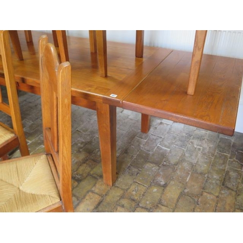 682 - An oak French made dining table with two additional leaves and eight rush seated chairs including tw... 