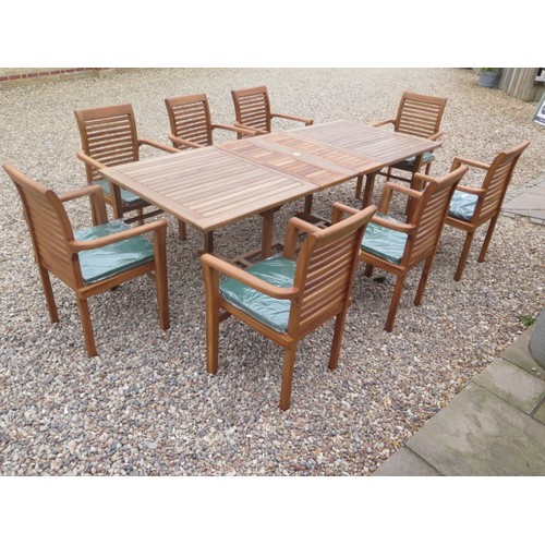 705 - A teak extending garden table with eight chairs and cushions - as new