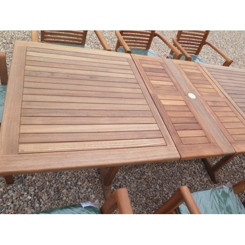 705 - A teak extending garden table with eight chairs and cushions - as new