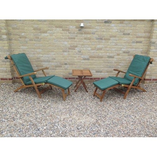 706 - A pair of teak steamer garden chairs and a coffee table with cushions - as new