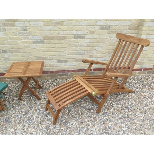 706 - A pair of teak steamer garden chairs and a coffee table with cushions - as new