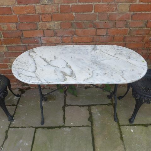 103 - A marble top garden table with a pair of ornate metal chairs, table 73cm tall x 120cm x 60cm