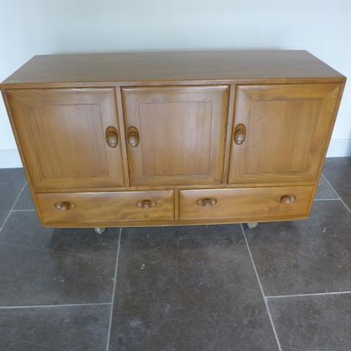 154 - An Ercol Golden Dawn elm sideboard with three cupboards above two drawers - good condition, some mar... 