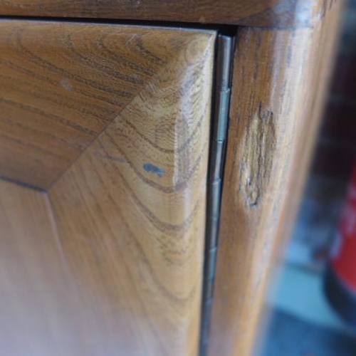 154 - An Ercol Golden Dawn elm sideboard with three cupboards above two drawers - good condition, some mar... 