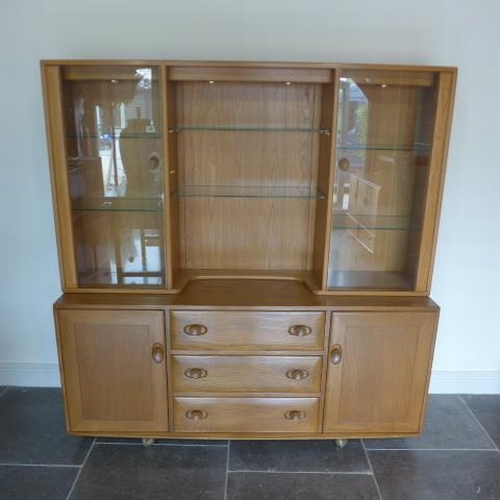 155 - An Ercol Golden Dawn blonde elm sideboard with glazed two door top over two cupboards and three draw... 