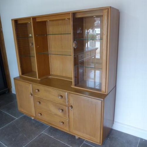 155 - An Ercol Golden Dawn blonde elm sideboard with glazed two door top over two cupboards and three draw... 