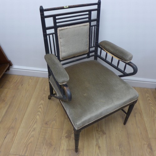 A Victorian ebonised William Morris / Sussex style open armchair with padded back arms and seat,  one stretcher broken and missing front stretcher, otherwise generally good