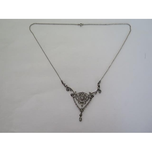 101 - A late Victorian diamond set negligee necklace with white trace link chain and scrolled supports to ... 