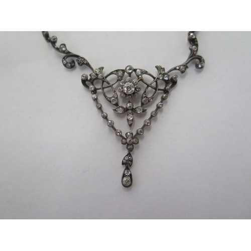 101 - A late Victorian diamond set negligee necklace with white trace link chain and scrolled supports to ... 