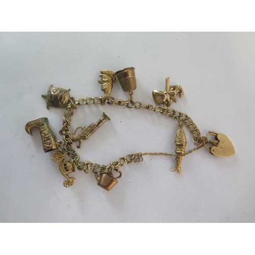 136 - A 9ct gold bracelet with ten assorted charms - total weight approx 17 grams