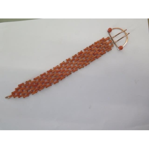 69 - A coral bracelet comprising four and three pinioned rectangular sections of coral to a large yellow ... 