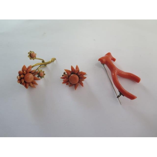 70 - Three coral brooches, two in floral form and one stick coral brooch in wishbone form - all on base m... 