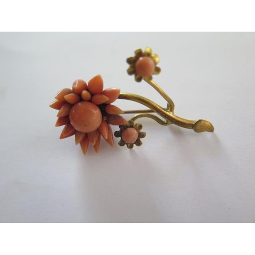 70 - Three coral brooches, two in floral form and one stick coral brooch in wishbone form - all on base m... 