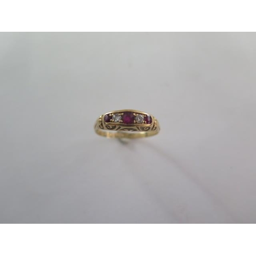 57 - A ruby and diamond half hoop ring - cast scrolled shoulders and bezel set with three mixed cut rubie... 