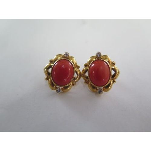 65 - A pair of Mediterranean coral stud earrings, oval cabochon cut, rub over set in a scalloped surround... 