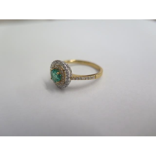 38 - A hallmarked 18ct yellow gold emerald and diamond Halo ring size O - the central emerald approx 0.48... 