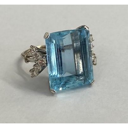 A good aquamarine and diamond white metal ring (possibly platinum) the large emerald cut aquamarine measures approx 13ct, 16.8mm x 13.6mm x 8.5mm flanked either side by 5 diamonds in a fine wire ring set - ring size L/M - in good condition