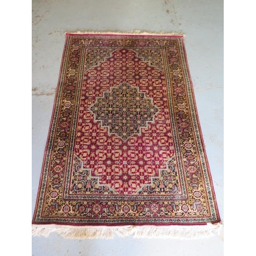 522 - A fine woven silk mix rug with a red field, central medallion and stylized boarder - 192cm x 121cm -... 