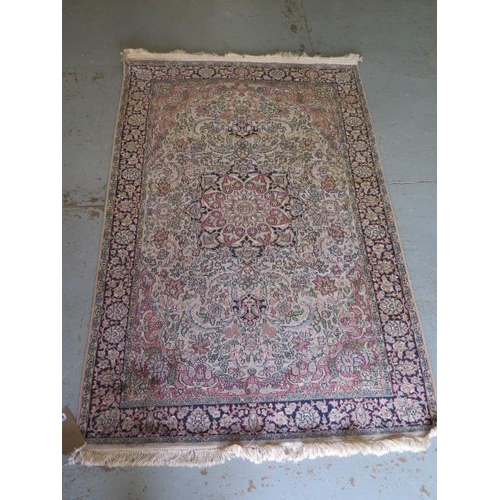 523 - A fine woven silk mix rug with cream field and dark blue boarder - 192cm x 123cm - some slight wear ... 