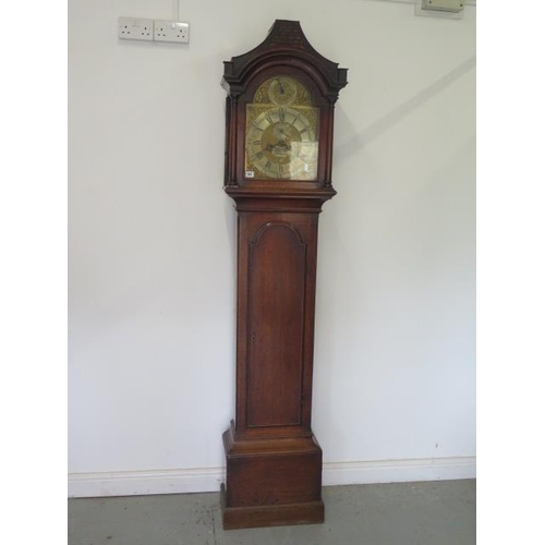 541 - An oak 8 day striking longcase clock with a brass arched 12