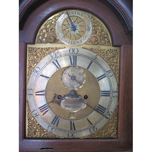 541 - An oak 8 day striking longcase clock with a brass arched 12