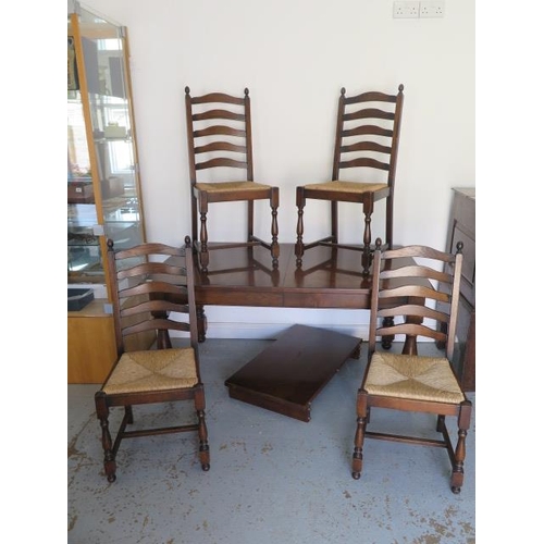 609 - An oak pull out dining table with one extra leaf and four rush seated chairs - Table 74cm tall x 91c... 