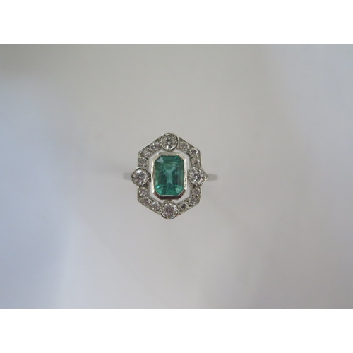 128 - A platinum art deco style emerald and diamond ring - the emerald of a good colour with natural inclu... 