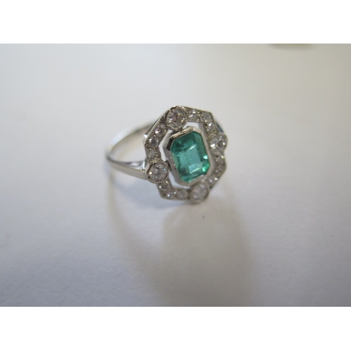 128 - A platinum art deco style emerald and diamond ring - the emerald of a good colour with natural inclu... 