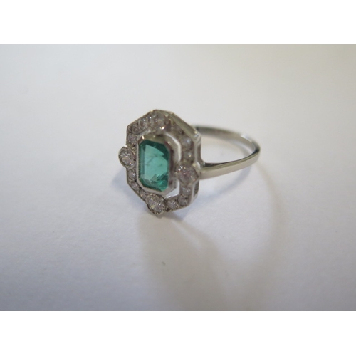 128 - A platinum art deco style emerald and diamond ring - the emerald of a good colour with natural inclu... 