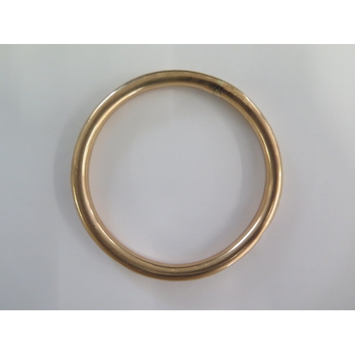 141 - A 9ct gold hollow bangle - 8.5cm external - approx weight 18.4 grams - some dents and repairs