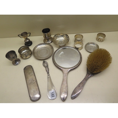 182 - A collection of silver items including serviette rings, silver back brush and mirror etc - total wei... 