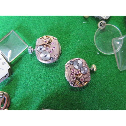 203 - A collection of assorted watch movements and parts including two Omega watch movements