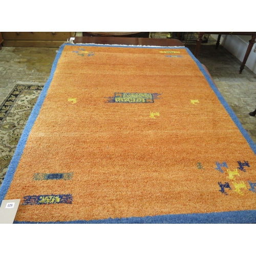 523 - A woollen rug with an orange field - some wear to edges - 197cm x 129cm