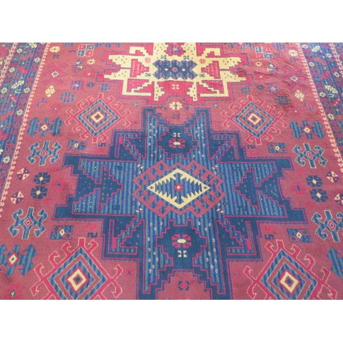 525 - A Saint-Maclon woollen rug with a red field - 356cm x 252cm