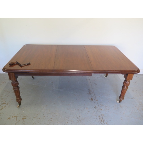 555 - A Victorian mahogany windout dining table with one leaf on turned fluted legs - Height 73cm x 100cm ... 