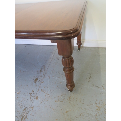 555 - A Victorian mahogany windout dining table with one leaf on turned fluted legs - Height 73cm x 100cm ... 