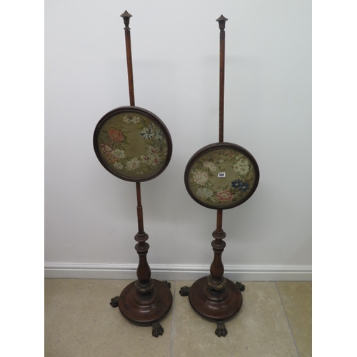 588 - A pair of mahogany pole fire screens with needlework designs - Height 145cm