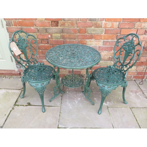 601 - A vintage green painted rose design cast aluminium bistro set comprising table Diameter 65cm x Heigh... 