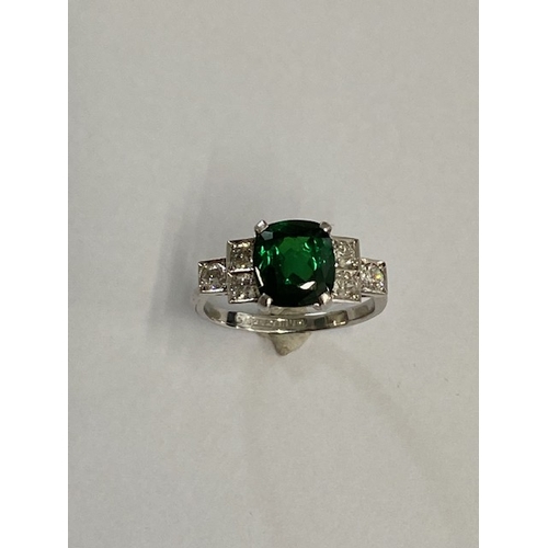 86 - A good platinum deep green Tsavorite and diamond ring - the central stone approx 3.02ct with six sur... 