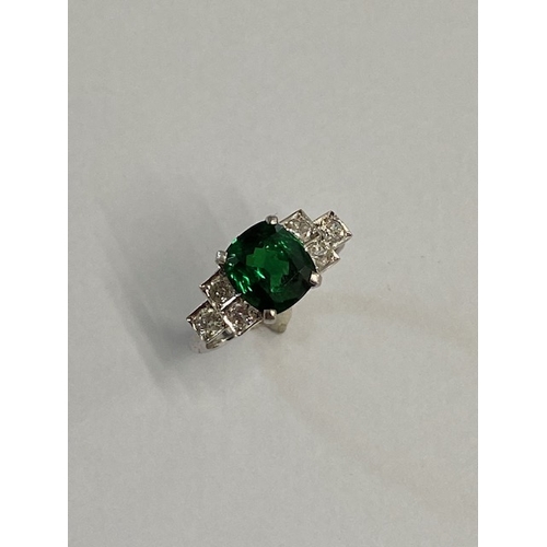 86 - A good platinum deep green Tsavorite and diamond ring - the central stone approx 3.02ct with six sur... 