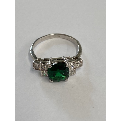 86 - A good platinum deep green Tsavorite and diamond ring - the central stone approx 3.02ct with six sur... 