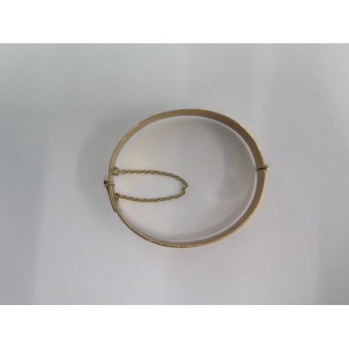 71 - A hallmarked 9ct yellow gold hinged bangle - 6.5cm x 5.5cm external - approx weight 24.7 grams - in ... 