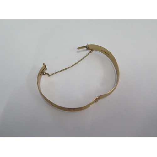 71 - A hallmarked 9ct yellow gold hinged bangle - 6.5cm x 5.5cm external - approx weight 24.7 grams - in ... 