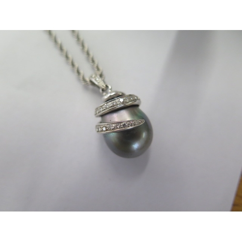 118 - A white metal diamond set tear drop black pearl pendant on an 18ct white gold 42cm chain along with ... 