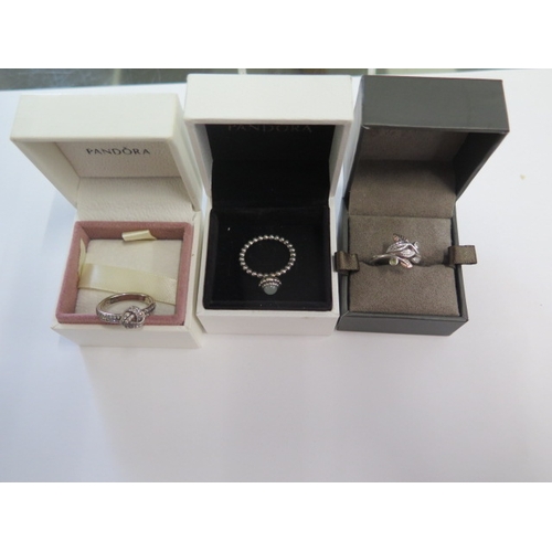 106 - Two Pandora silver rings sizes K and L and a Clogau rolled gold ring size J - all generally good