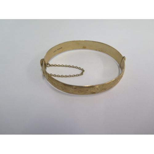 71 - A hallmarked 9ct yellow gold hinged bangle - 6.5cm x 5.5cm external - approx weight 24.7 grams - in ... 