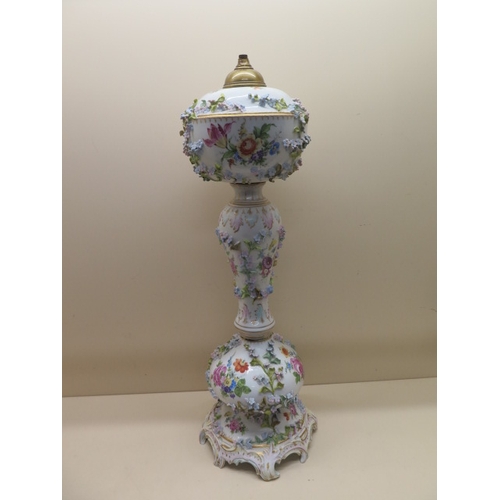 413 - A Continental floral encrusted porcelain oil lamp stand - Height 61cm - some foliate losses and firi... 