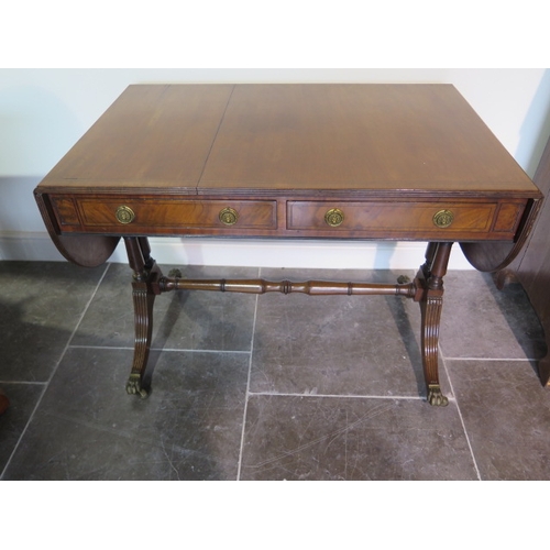 526 - A 19th century mahogany drop leaf sofa table with two active and two dummy drawers on twin pillar su... 